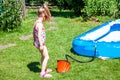 Little girl blowing up inflatable swimming pool Royalty Free Stock Photo