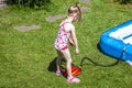 Little girl blowing up inflatable swimming pool Royalty Free Stock Photo