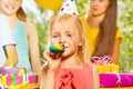 Little girl blowing whistle at the birthday party Royalty Free Stock Photo