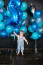 Little girl with blue balloons on a black background. Children`s birthday 2 years Royalty Free Stock Photo