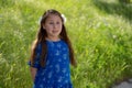 Little Girl in Blue Dress Smiling in Front of Field with Flowers Royalty Free Stock Photo