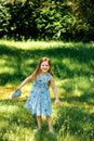 Little girl in a blue dress with a blue bag in summer garden Royalty Free Stock Photo