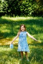 Little girl in a blue dress with a blue bag in summer garden Royalty Free Stock Photo