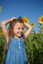 Little girl in blue dress in a field of sunflowers Royalty Free Stock Photo