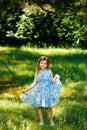 Little girl in a blue dress in hands in summer garden Royalty Free Stock Photo