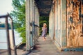 Little girl standing on porch of old ruined house.