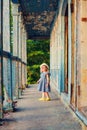 Little girl standing on porch of old ruined house.