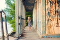 Little girl standing on porch of old ruined house. Royalty Free Stock Photo