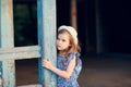 Little girl standing on porch of old ruined house. Royalty Free Stock Photo