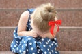 Little girl in a blue dress sits on the steps and cries Royalty Free Stock Photo