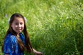 Little Girl in Blue Dress Smiling in Front of Field with Flowers Royalty Free Stock Photo