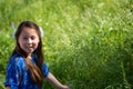 Little Girl in Blue Dress Smiling in Front of Field with Flowers Royalty Free Stock Photo