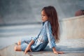 Little girl in blue wear posing for a camera in the city when leaning on the ramp Royalty Free Stock Photo