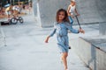 Little girl in blue wear posing for a camera in the city when leaning on the ramp Royalty Free Stock Photo