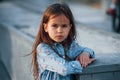 Little girl in blue wear posing for a camera in the city when leaning on the ramp Royalty Free Stock Photo