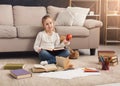 Little girl with book and apple at home Royalty Free Stock Photo