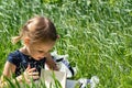 Little girl with a book in the garden. Kid is readding a book. A little girl 4-5 years old sits on the grass and reads a book