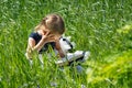 Little girl with a book in the garden. Kid is readding a book. A little girl 4-5 years old sits on the grass and reads a book