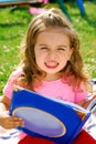 Little girl with a book in the garden Royalty Free Stock Photo