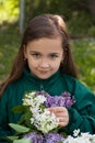 Little Girl With Bouquet Of Lilac Flowers In Garden.