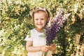 Little girl with  bouquet of lupines on the field in the summer. Blooming lupine flowers. Nature concept Royalty Free Stock Photo