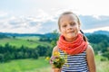 little girl with a bouquet of wild flowers on a background of a