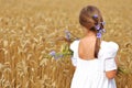 Little girl with a bouquet of wildflowers in her hands in a wheat field. Royalty Free Stock Photo