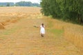 Little girl with a bouquet of wildflowers in her hands in a wheat field.