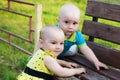 Little girl and boy climb on a bench