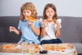 Little girl and boy eat pizza. Hungry children eating pizza. Unhealthy fast food. Royalty Free Stock Photo