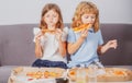 Little girl and boy eat pizza. Hungry children eating pizza. Unhealthy fast food. Royalty Free Stock Photo