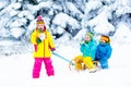 Kids on sleigh ride. Children sledding. Winter snow fun. Royalty Free Stock Photo