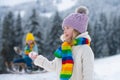 Little girl and boy enjoying a day out playing in the winter forest. Children siblings having fun in beautiful winter Royalty Free Stock Photo