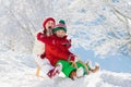 Little girl and boy enjoying sleigh ride. Child sledding. Toddler kid riding a sledge. Children play outdoors in snow. Kids sled Royalty Free Stock Photo