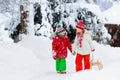 Little girl and boy enjoying sleigh ride. Child sledding. Toddler kid riding a sledge. Children play outdoors in snow. Kids sled Royalty Free Stock Photo