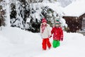 Little girl and boy enjoying sleigh ride. Child sledding. Toddler kid riding a sledge. Children play outdoors in snow. Kids sled Royalty Free Stock Photo