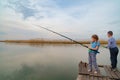 little girl and boy fish on a fishing rod standing on a wooden bridge. fishermen Royalty Free Stock Photo