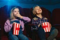 Little girl and boy watching a film at a movie theater