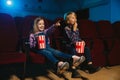 Little girl and boy watching a film at a movie theater