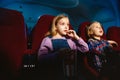 Little girl and boy watching a film at a movie theater Royalty Free Stock Photo