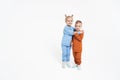 A little girl and a boy hug. Children& x27;s love. On a monochromatic background, children in sportswear. Blue tracksuit Royalty Free Stock Photo