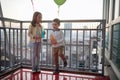 Little girl and boy are playing with balloons and enjoying a drink on the terrace of an apartment. Family, together, party Royalty Free Stock Photo