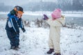 Little girl and boy playing in the snow on cold winter day. Royalty Free Stock Photo