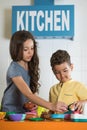 Little girl and boy playing with toy kitchen. Royalty Free Stock Photo