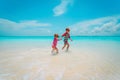 Little girl and boy run play with water on beach Royalty Free Stock Photo