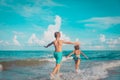 little girl and boy run and play with water at beach Royalty Free Stock Photo