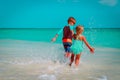 Little girl and boy run play with water on beach Royalty Free Stock Photo