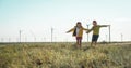 Little girl and boy are running in front of windmills. Renewable energies and sustainable resources - wind mills Royalty Free Stock Photo