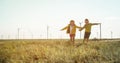 Little girl and boy are running in front of windmills. Renewable energies and sustainable resources - wind mills Royalty Free Stock Photo