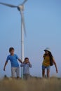 Little girl and boy are running in front of windmills. Renewable energies and sustainable resources wind mills. Children Royalty Free Stock Photo